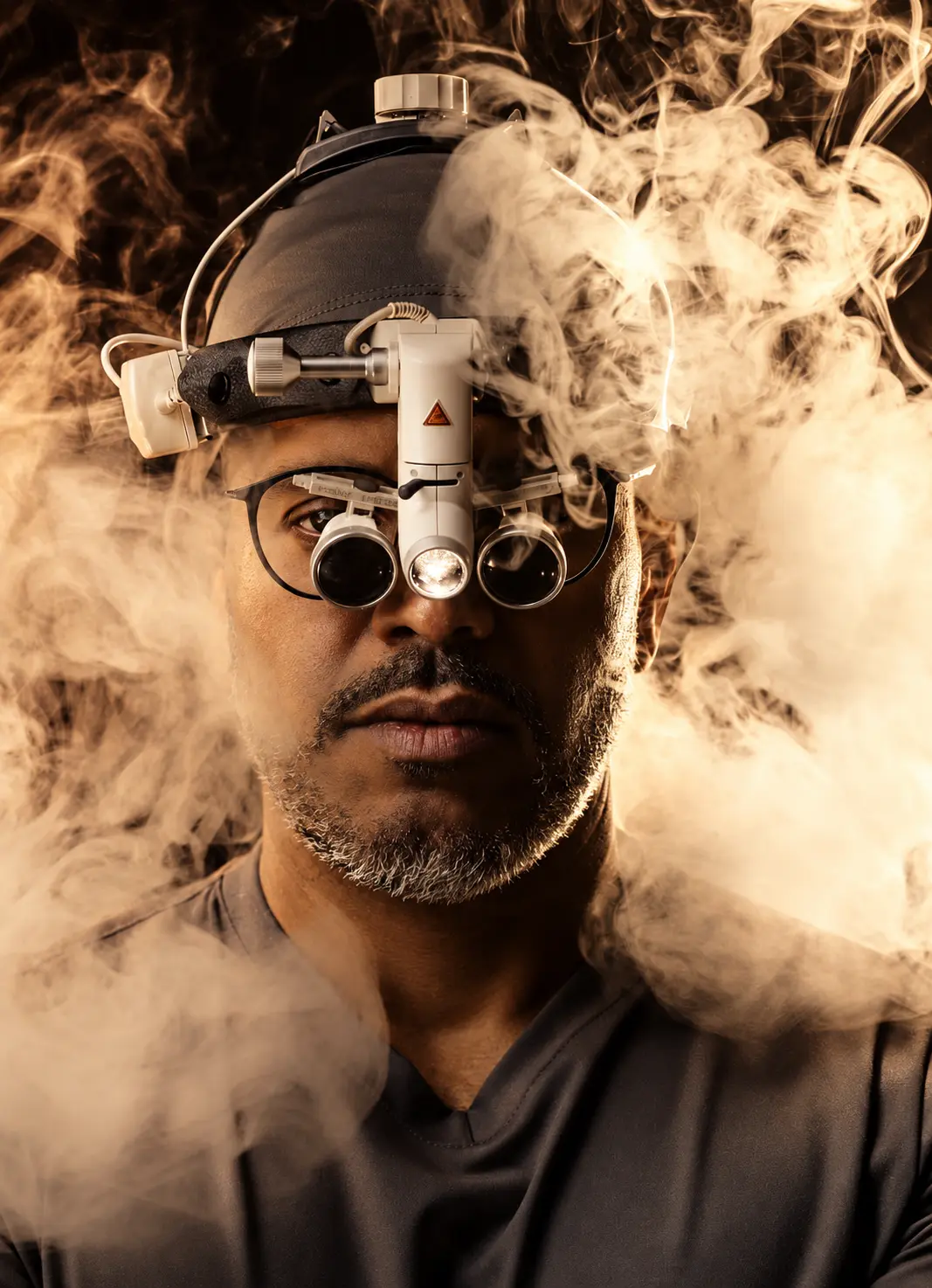 Dr. Pierre Costa com lupa cirúrgica e fotóforo, em luz caramelo